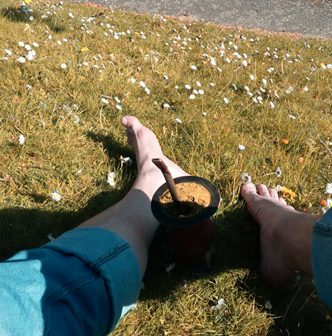 Sentado no gramado bebendo chimarrão